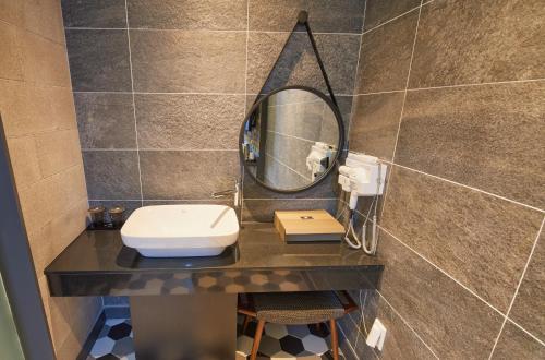 a bathroom with a sink and a mirror on a counter at K Boutique Hotel in Yeosu