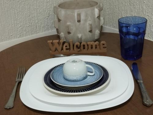 a table with a plate and a teapot on it at Queen's Flats, flat executivo próximo à Esplanada e ao aeroporto in Brasilia
