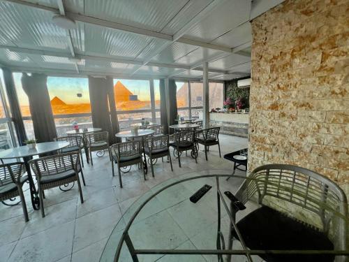 a restaurant with tables and chairs and a brick wall at Pyramids View Inn in Cairo
