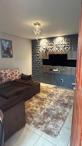 a living room with a couch and a television at LUZ DO LUAR in Pedra Azul
