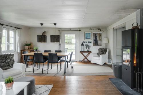 a dining room and living room with a table and chairs at Swedish Cottage By Forest And Lake In Småland in Traryd