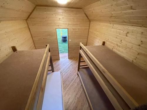 a small wooden room with two beds in it at Areál Kamínka - CHATKA PREMIUM in Roštín