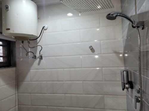 a shower with a shower head in a bathroom at Caesar's Hotel & Apartment Room #4 in Ikeja