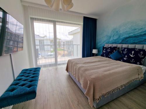 a bedroom with a large bed and a large window at Rezydencja Niechorze Lazurowy A326 z dostępem do Basenu in Niechorze