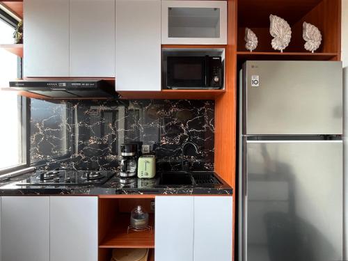 a kitchen with white cabinets and a stove top oven at 3BR Brand New Cozy Private Villa D'Pondok Balangan in Uluwatu