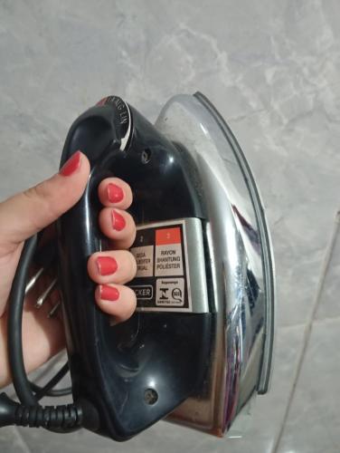 a person holding a hair dryer in their hand at Residencial Lima - Quarto 03 in São Luís