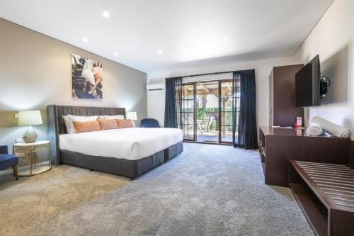 a bedroom with a bed and a flat screen tv at Nightcap at Macquarie Inn in Dubbo