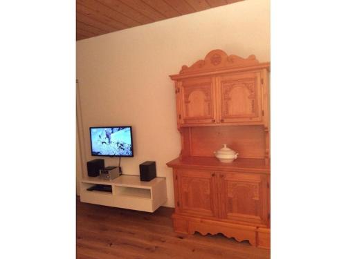 a living room with a tv and a wooden cabinet at Modern Apartment Hochkönig Region in Bachwinkl