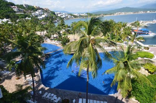 an aerial view of a resort swimming pool with palm trees at Las Hadas by Brisas in Manzanillo