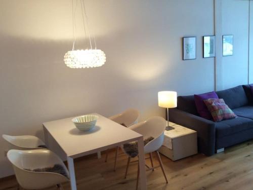 a living room with a table and a blue couch at Modern Apartment Hochkönig Region in Bachwinkl