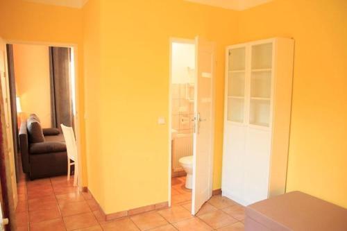 a yellow room with a toilet and a couch at Holiday apartment for 4 people, Lubin in Lubin