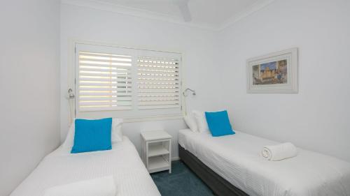 扬巴Avalon 2的一间带窗户的白色房间里有两张床