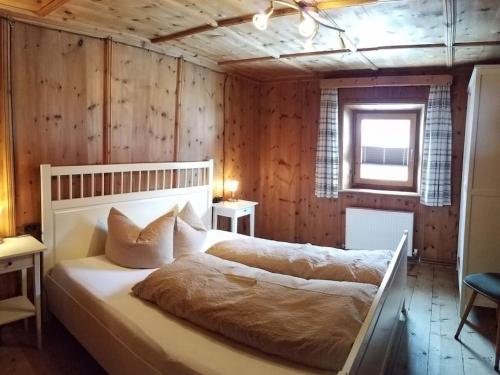 a bedroom with two beds in a room with wooden walls at Apartment in Umhausen with swimming pool in Umhausen