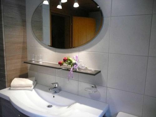 措布伦Cabin in Zöblen with swimming pool的带水槽和镜子的浴室