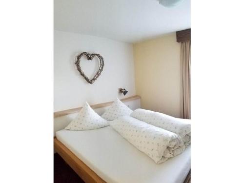 a bedroom with a bed with a heart on the wall at Edelweiss Riding stable Alpine Appart in Umhausen