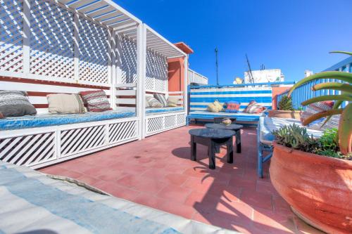 a patio with two benches and a table on a patio at Les Matins Bleus in Essaouira