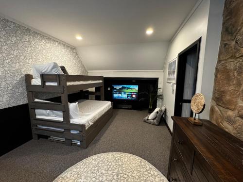 a bedroom with a bunk bed and a television at Italy Inspired Lakeview Chalet with Hot Tub in Lake Harmony