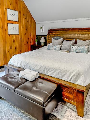 a bedroom with a large bed with a leather seat at Italy Inspired Lakeview Chalet with Hot Tub in Lake Harmony