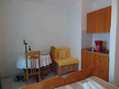 een kleine keuken met een tafel en een stoel bij Apartments in Sabunike - Zadar Riviera 7981 in Batalaži