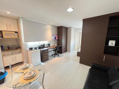 a living room with a glass table and a desk at LK Estoril 2 in Belo Horizonte