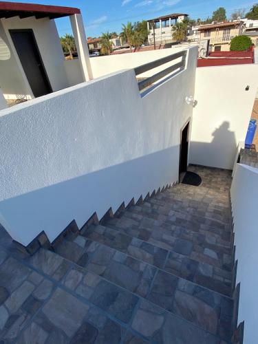 a stairway leading up to a white wall with a tile floor at New Fully Furnished Vacation House in San Felipe