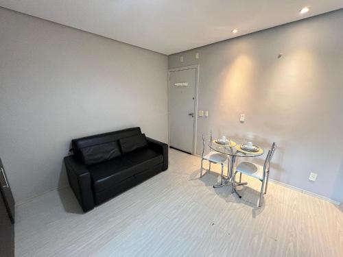a living room with a couch and a table and chairs at LK Estoril 2 in Belo Horizonte