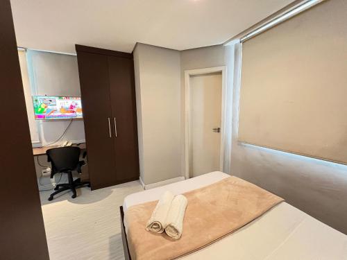 a bedroom with a bed with two towels on it at LK Estoril 2 in Belo Horizonte