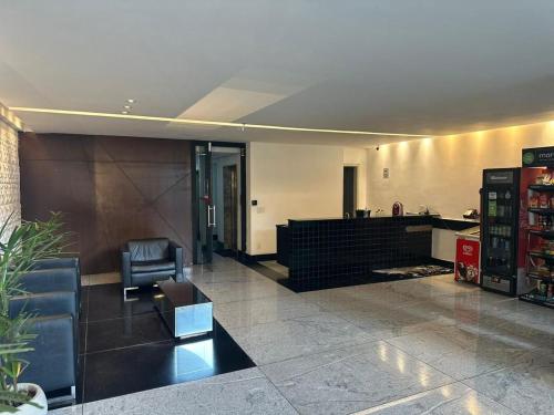 a lobby with a chair and a desk in a building at LK Estoril 2 in Belo Horizonte
