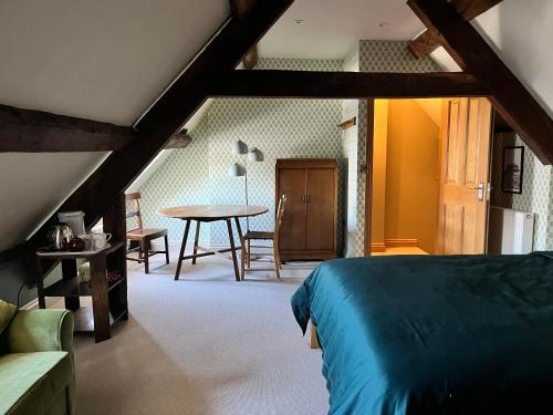 a bedroom with a bed and a table in a room at Rooftops Loft in Hay-on-Wye