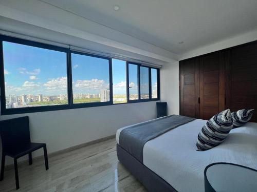 a bedroom with a large bed and a large window at Top floor, amazing sea view in Puerto Cancun in Cancún