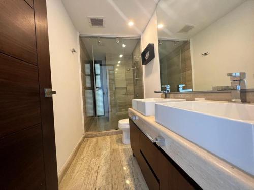 a bathroom with a sink and a toilet and a mirror at Top floor, amazing sea view in Puerto Cancun in Cancún