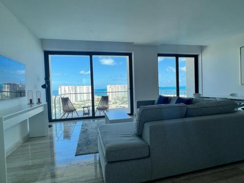 a living room with a couch and views of the ocean at Top floor, amazing sea view in Puerto Cancun in Cancún