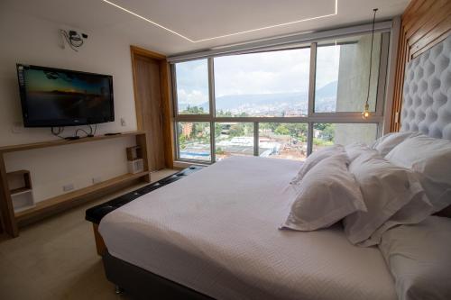 una camera da letto con un letto grande con una grande finestra di Penthouse de Lujo con Jacuzzi y Vista a Itagüí