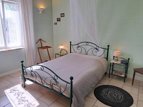 a bedroom with a bed with a metal frame at House near Lac de Madine with Historic Charm in Lahayville