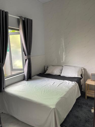 フエにあるCle homestayの窓のある部屋にある白いベッド