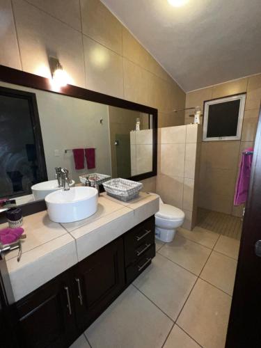 ein Badezimmer mit Waschbecken, Toilette und Spiegel in der Unterkunft Casa YOKO in Oaxaca de Juárez