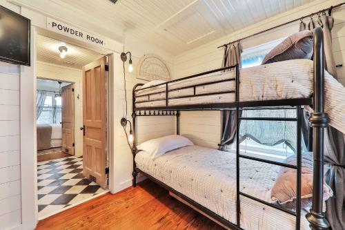a bedroom with two bunk beds and a checkered floor at Wake Up to Waves - 3BR on the Sand in Cedar Landing