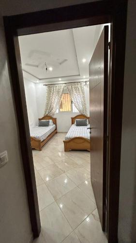 a room with two beds and a door to a bedroom at your home in Oued Laou