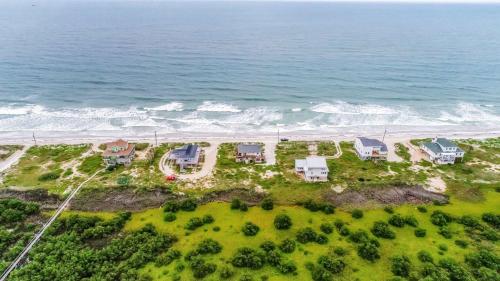 an aerial view of a beach with houses and the ocean at Wake Up to Waves - 3BR on the Sand in Cedar Landing