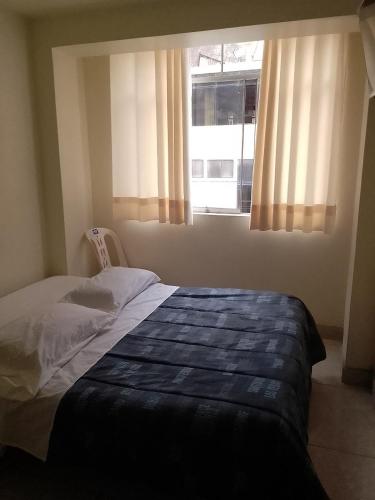 a bedroom with a bed and a window at Hospedaje TUTUMEME in Churín