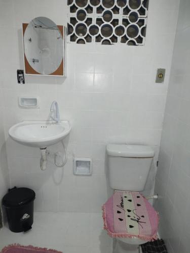 a white bathroom with a sink and a toilet at Pousada Villa Da Música Beira Mar Lótus Pontal Centro in Paraty
