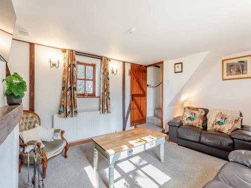 Rookery Cottage في Little Staughton: غرفة معيشة مع أريكة وطاولة