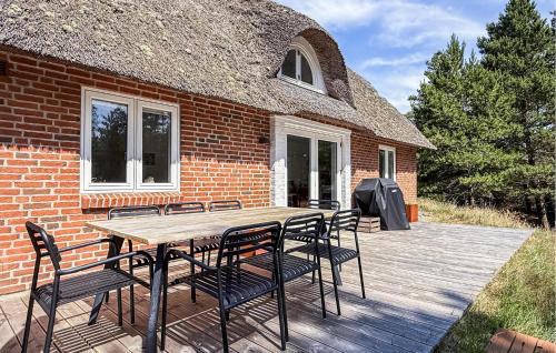 a patio with a table and chairs and a brick building at Holiday Home A Hveyselsvej Rømø V in Rømø Kirkeby