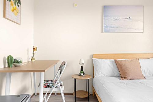 a bedroom with a bed and a table and a desk at Tranquil Double Room - Walk to Train & Cabramatta Eats - Shared Bathroom in Cabramatta