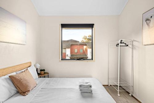 a white bedroom with a bed and a window at Tranquil Double Room - Walk to Train & Cabramatta Eats - Shared Bathroom in Cabramatta