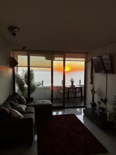 a living room with a couch and a view of the ocean at Jardín del Mar apartment in Coquimbo