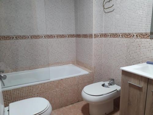 a bathroom with a toilet and a tub and a sink at Apartamento Turístico Céntrico Galper in Melilla