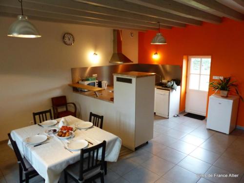 une cuisine avec une table et un chiffon de table blanc dans l'établissement Maison rénovée avec jardin, animaux acceptés, climatisation, parking - FR-1-489-36, à Agonges