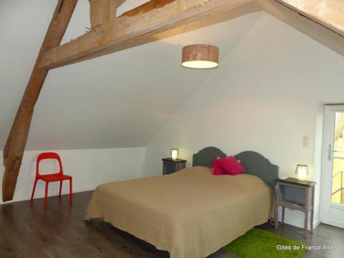 a bedroom with a bed and a red chair at Maison rénovée avec jardin, animaux acceptés, climatisation, parking - FR-1-489-36 in Agonges