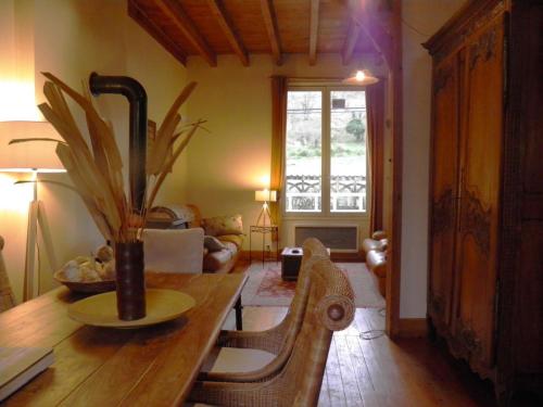 a living room with a table with a vase on it at Gîte cosy en bord de rivière avec jardin, proche village médiéval, idéal famille, animaux acceptés - FR-1-489-247 in Hérisson
